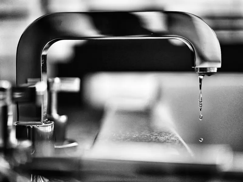 Verchromte Armatur mit laufendem Wassertropfen